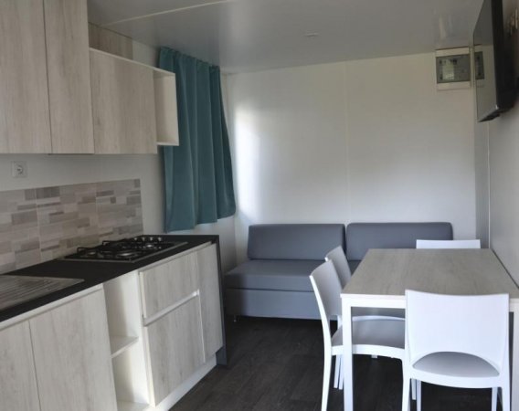 Sala con cucina moderna e soggiorno.