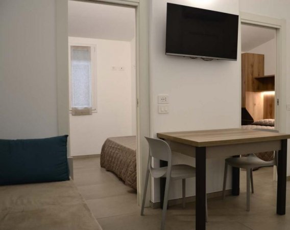 Un interno semplice con tavolo, sedie e letto.