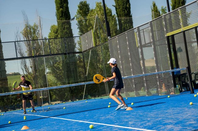 Due persone giocano a padel su un campo blu.