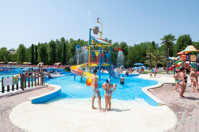Parco acquatico con scivoli colorati e piscina.