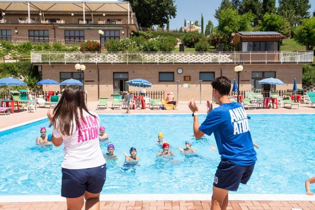 Animatori coordinano attività in piscina.