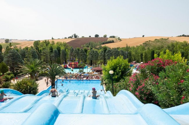 Scivoli d'acqua azzurri con vista su piscina e colline.