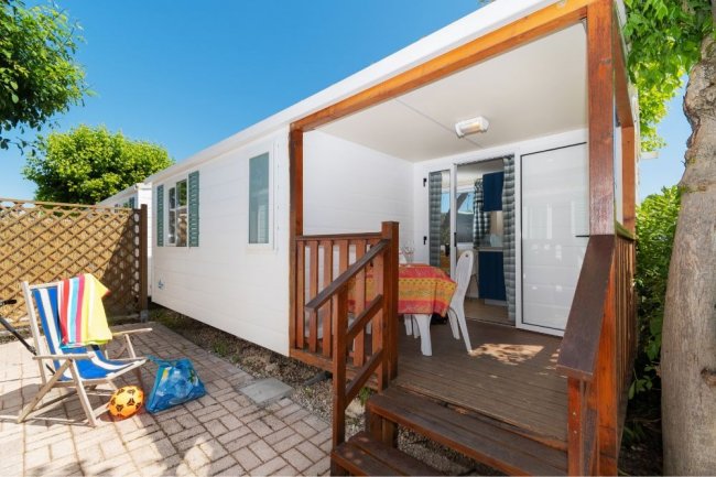 Veranda in legno con sedia a sdraio e pallone.