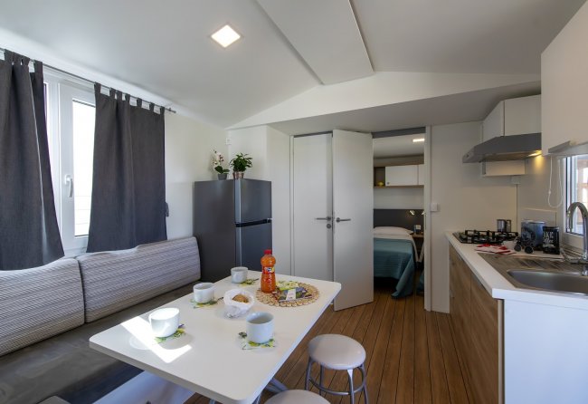 Cucina moderna con tavolo apparecchiato e divano.