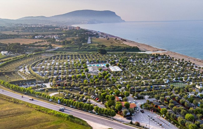 Campeggio vicino al mare con piscina e alberi.