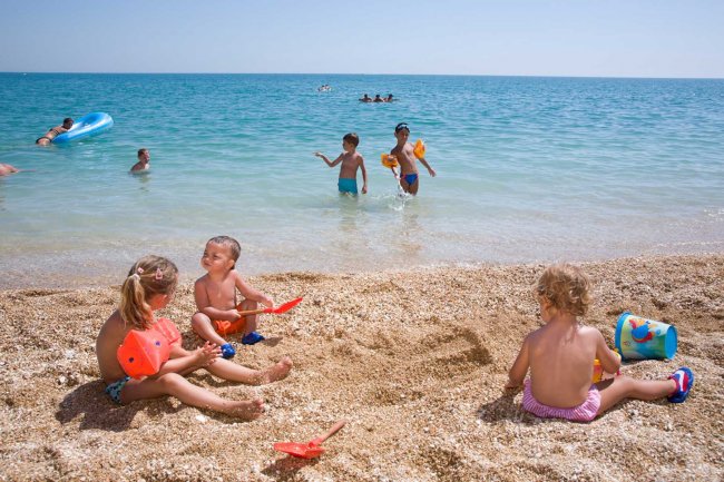 Bambini giocano sulla spiaggia vicino al mare.