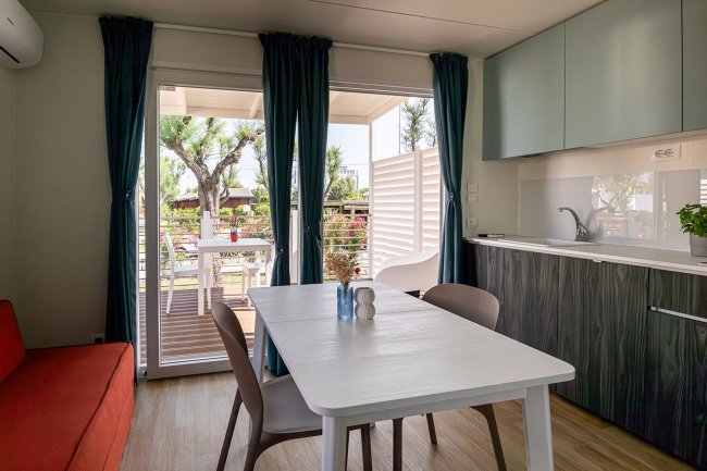 Interno di una cucina moderna con tavolo bianco.