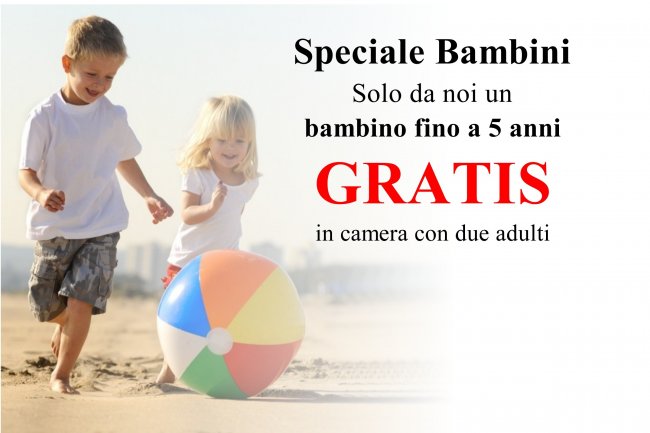 Bambini giocano sulla spiaggia con un pallone.