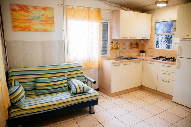 Cucina compatta con divano a righe colorate.