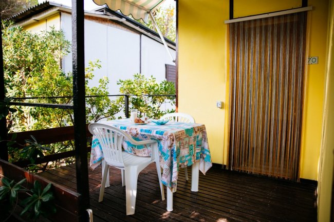 Terrazza con tavolo e sedie bianche.