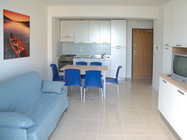 Cucina e soggiorno con tavolo e sedie blu.
