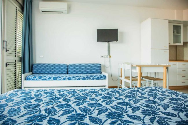 Interno di un appartamento con letto e divano blu.