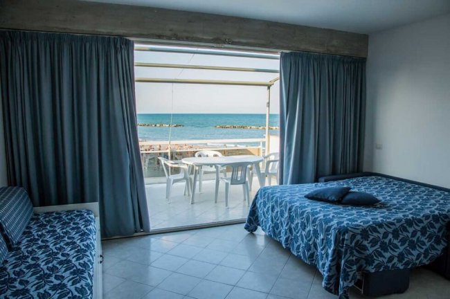 Camera con vista mare, letto e divano.