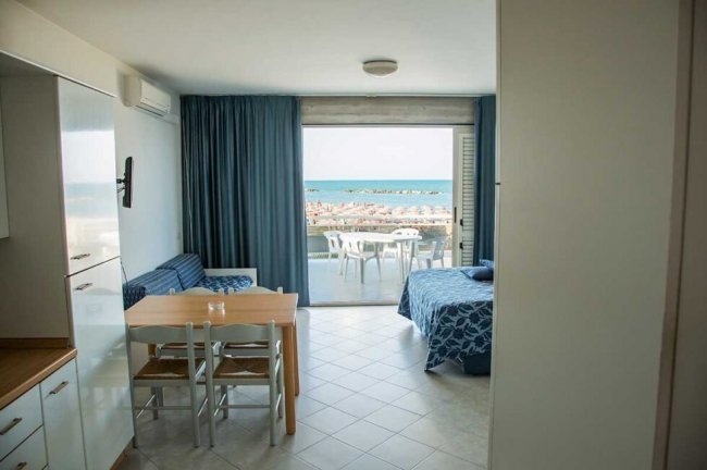 Stanza con vista mare, tavolo, divano e letto.