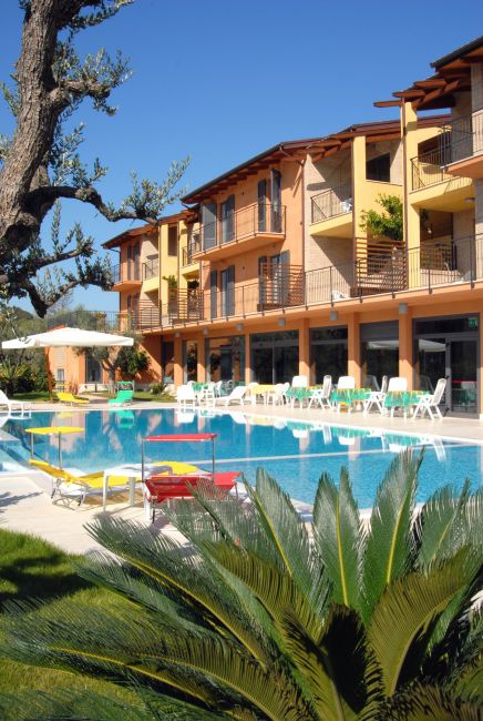 Hotel con piscina e sdraio all'aperto.
