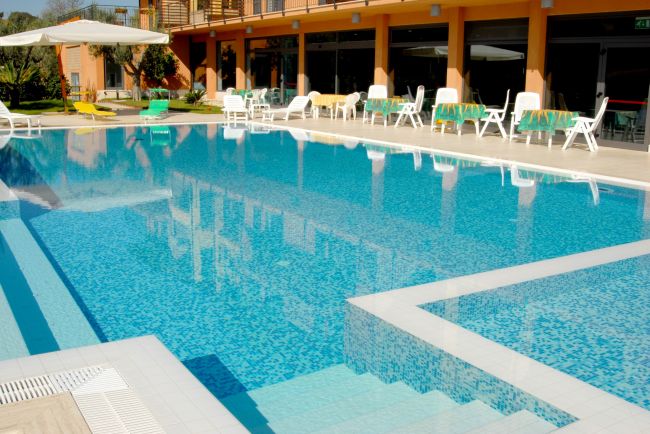 Piscina con lettini e ombrelloni.